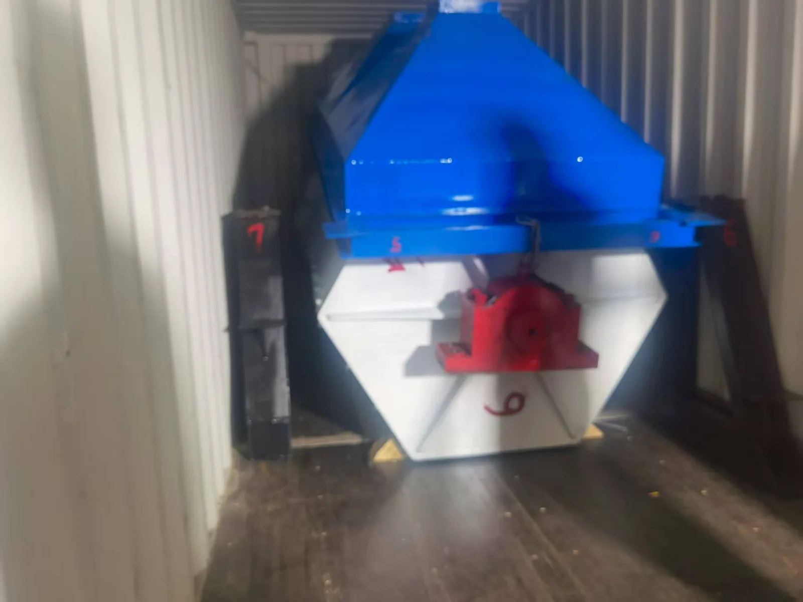 Compact cobblestone polishing machine secured inside a shipping container